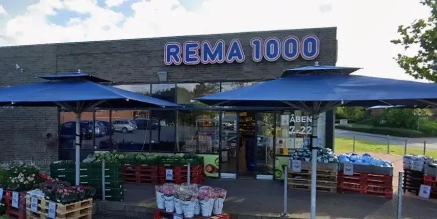 REMA 1000 store front with outdoor umbrellas and flower displays