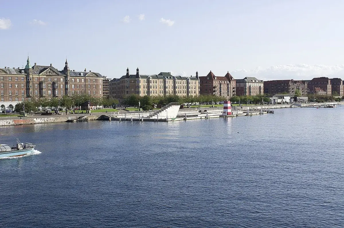 Wide view of the waterfront at Islands Brygge in Copenhagen with apartment buildings along the harbor.