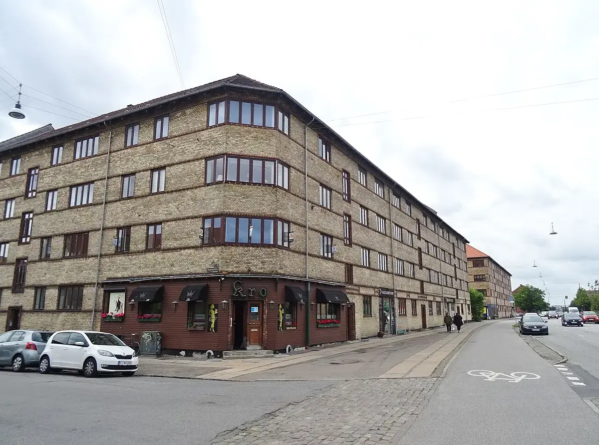 A large apartment building on a city street corner in Copenhagen.