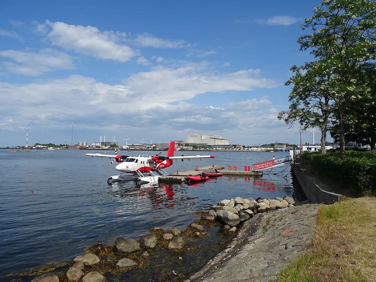 A red-and-white floatplane moored at a dock in Copenhagen.