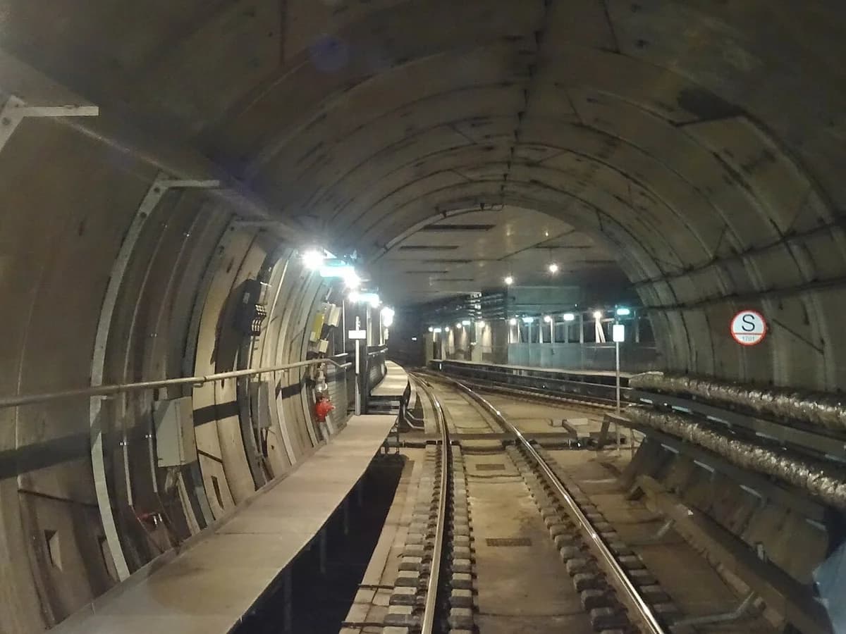 Underground metro tracks curving through a tunnel toward Copenhagen Central Station.