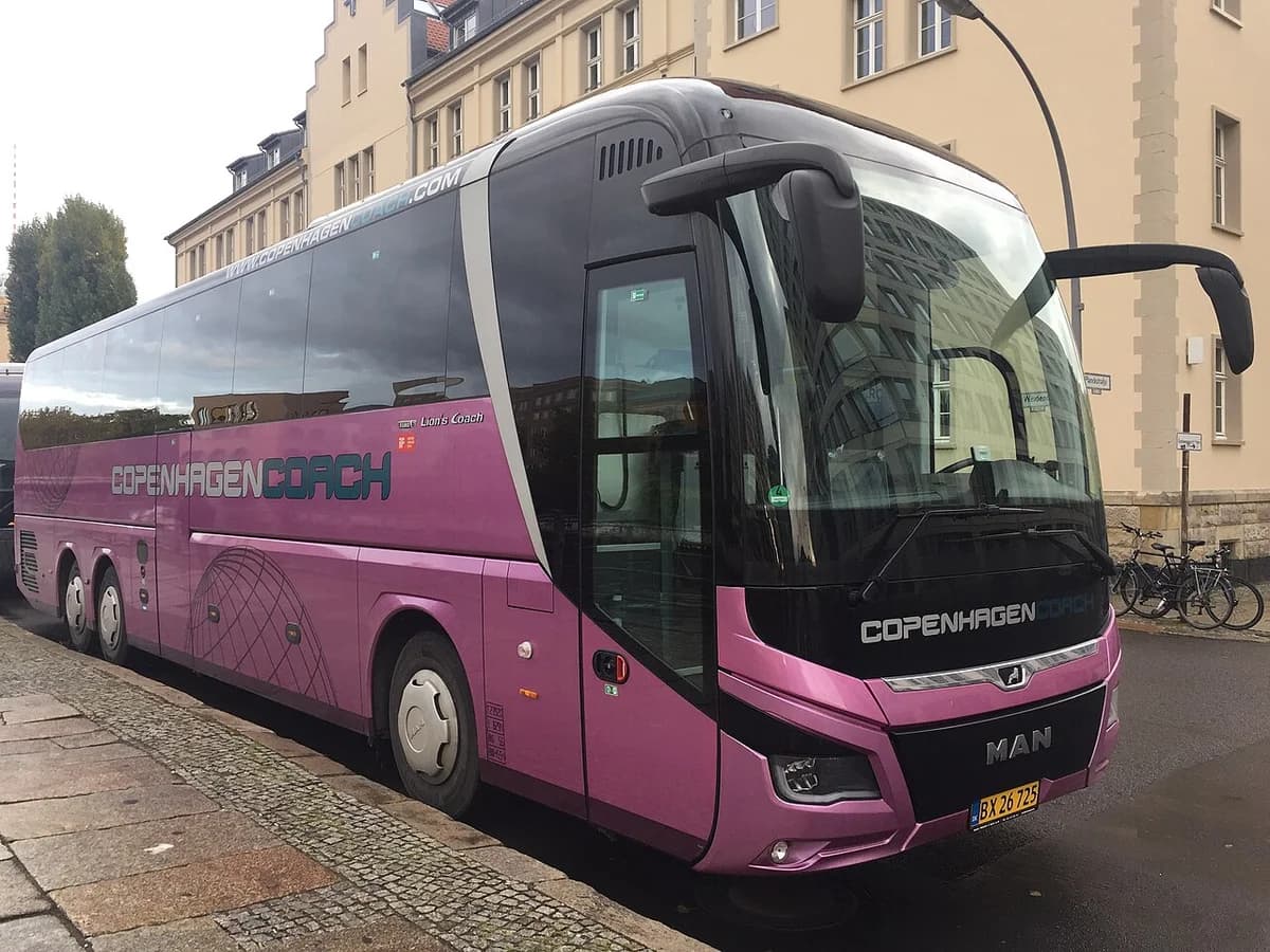 Purple MAN Lion's Coach bus branded 'Copenhagen Coach' parked on city street