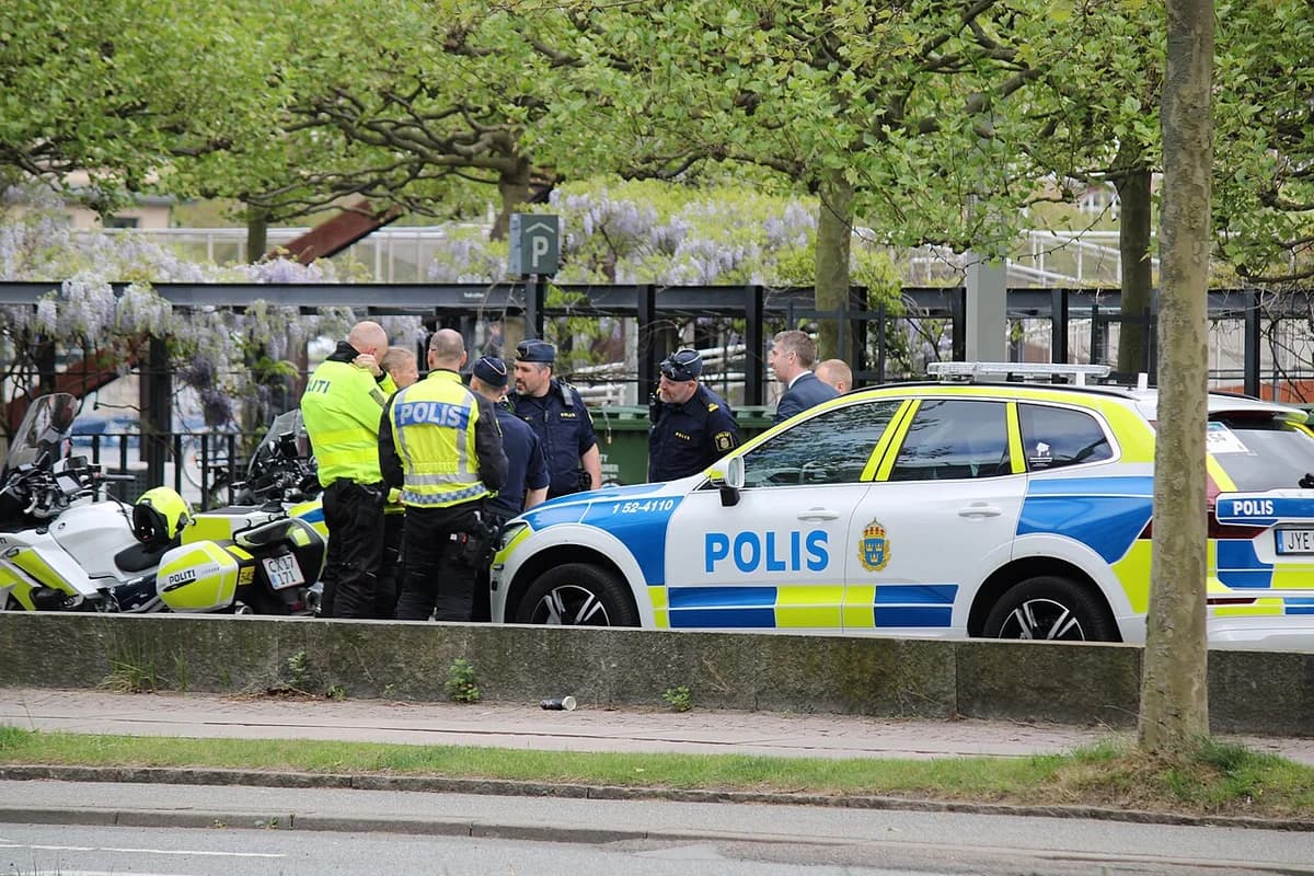 Swedish and Danish police officers standing near police vehicles outdoors