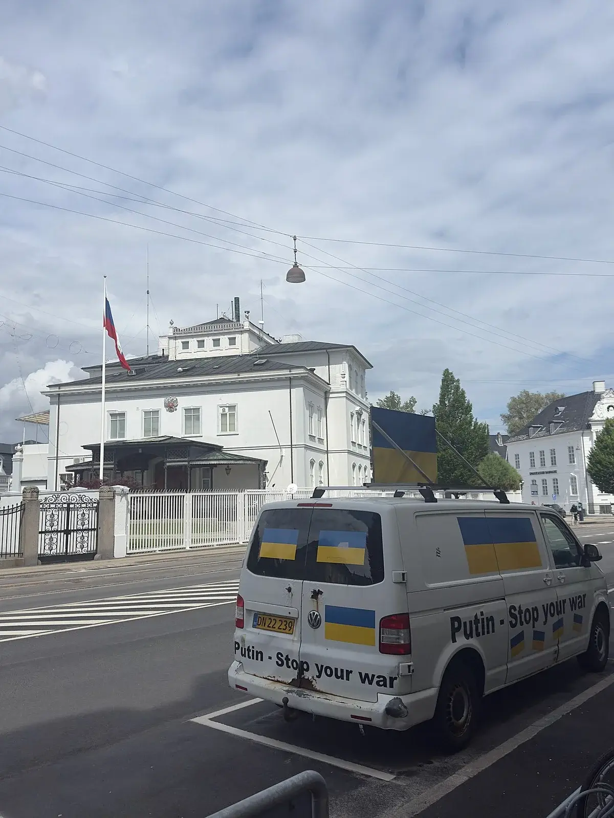 A van with Ukrainian flags and anti-war text parked outside the Russian Embassy in Copenhagen.