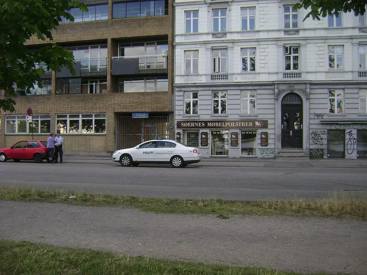Danish police car and officers beside a stopped red car on a Copenhagen street