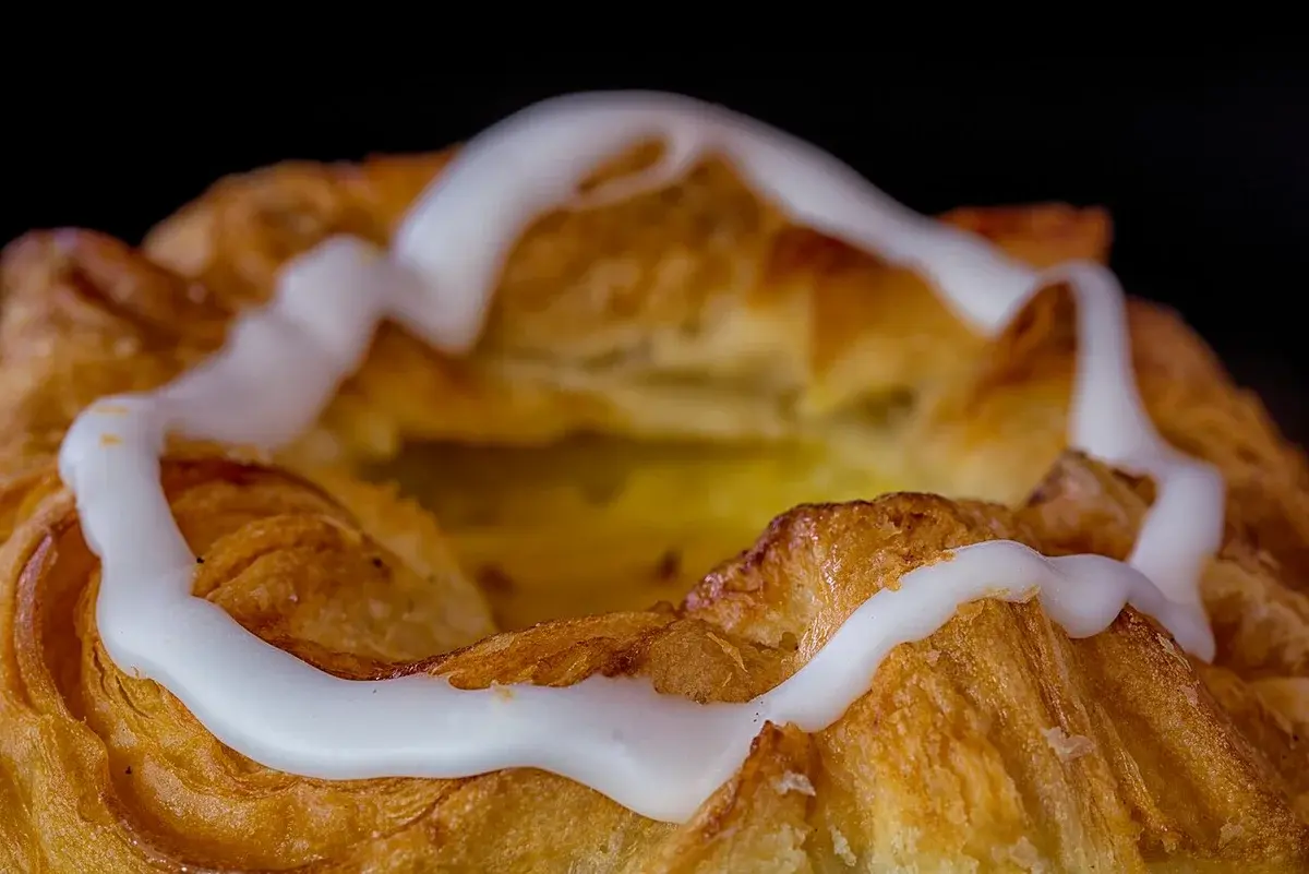 Close-up of a Danish pastry with white icing.