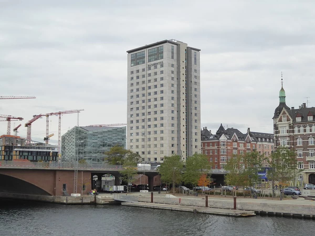 Tall Danhostel Copenhagen City building on the Copenhagen waterfront near a bridge.