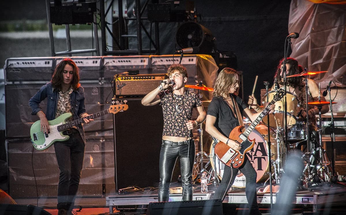 Greta Van Fleet performing live on stage with guitars and drums.