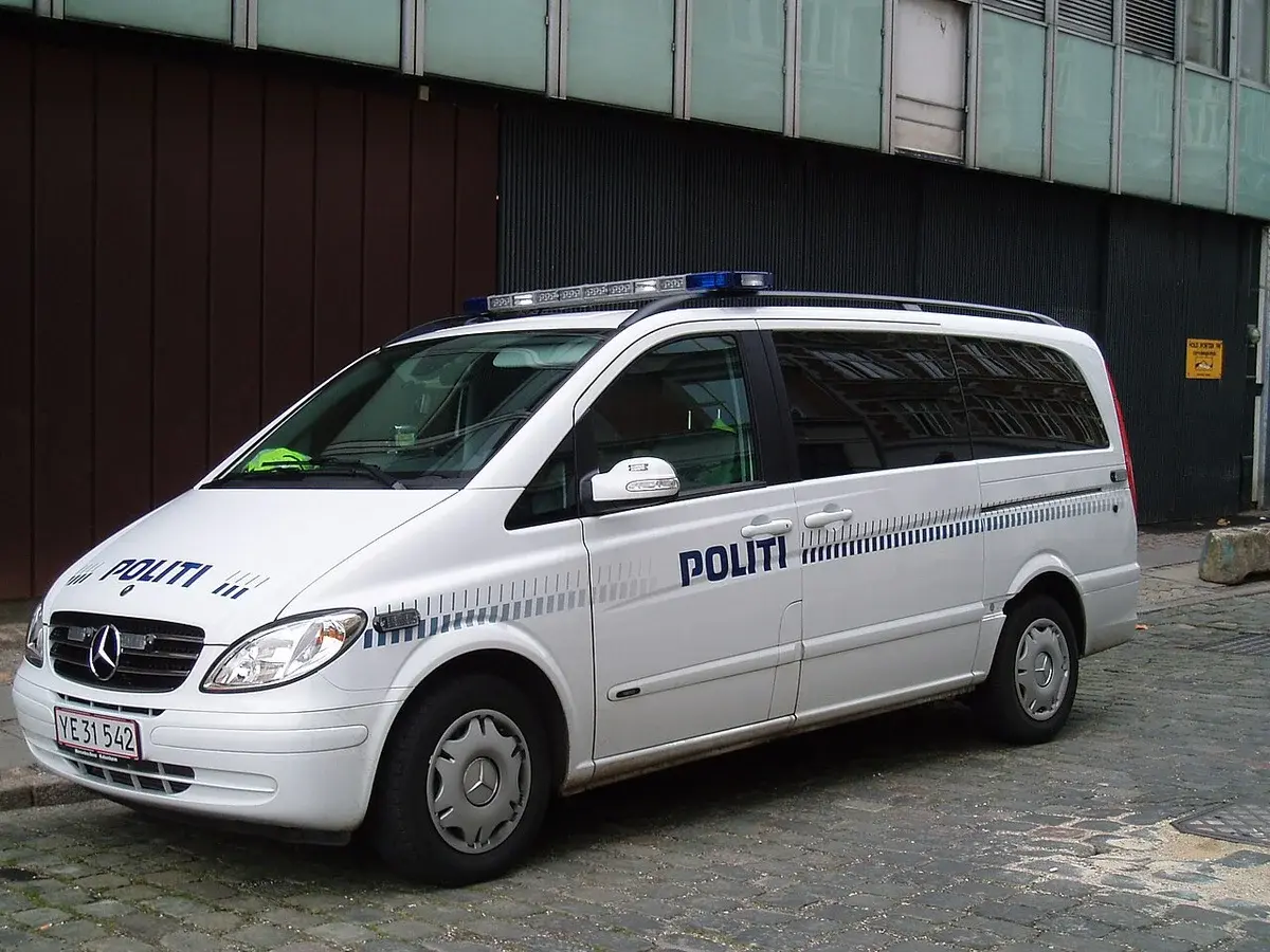 A white Copenhagen Police van parked on a cobblestone street.