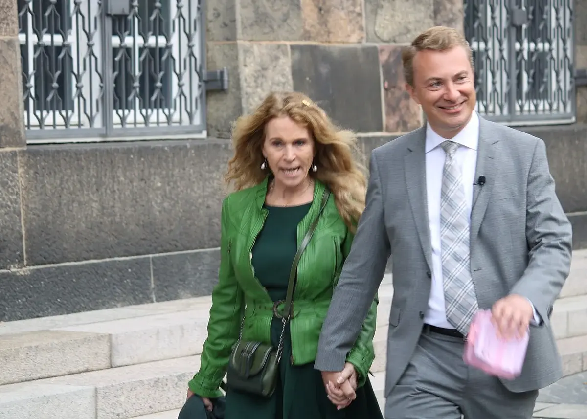 A woman and a man walking hand in hand outside Christiansborg.