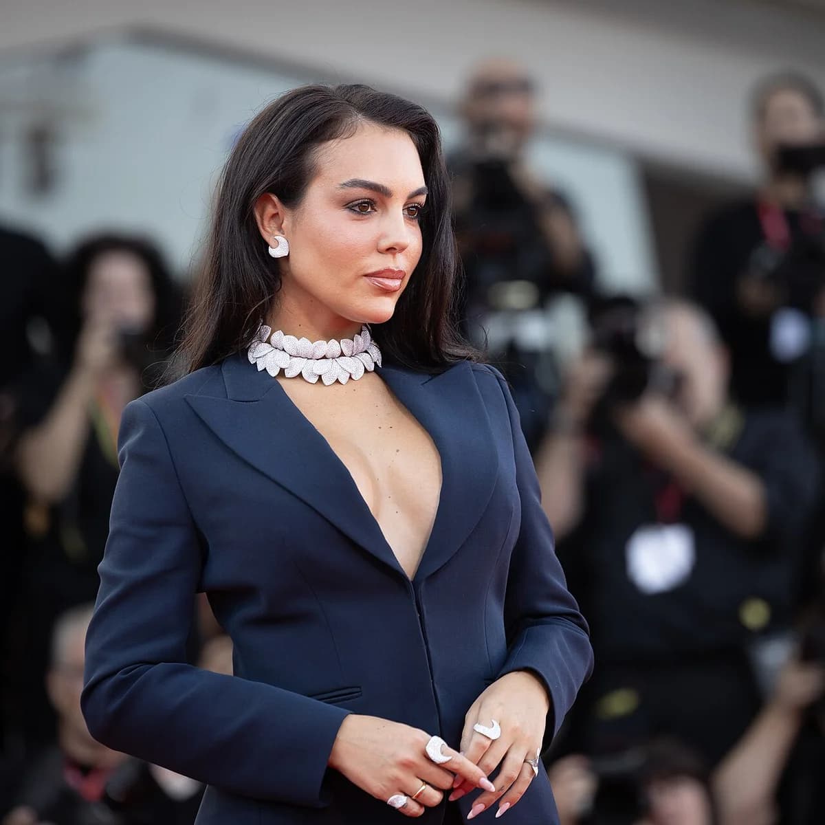 Georgina Rodríguez posing at the Venice Film Festival in a dark blue formal outfit.
