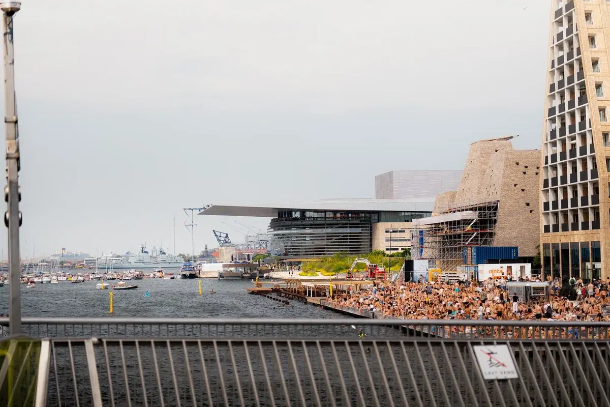 Crowded waterfront scene at Copenhagen harbor on a summer day.
