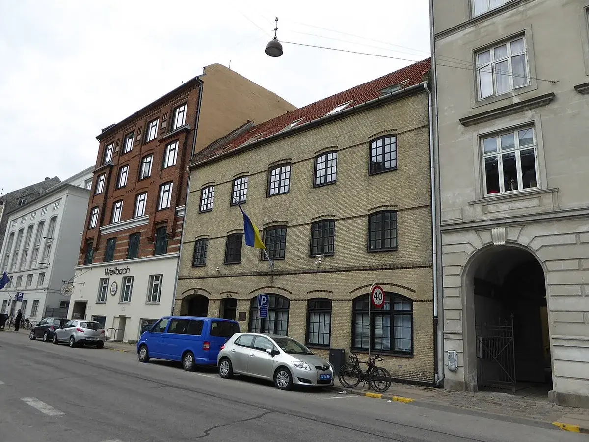 Street view of the Ukrainian Embassy in Copenhagen with a Ukrainian flag on the building.
