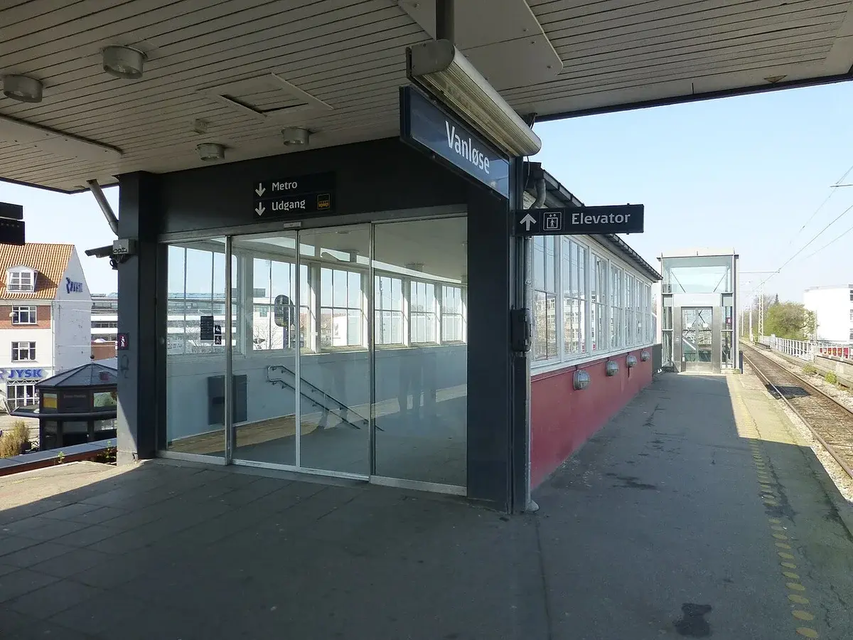 Vanløse Station platform area with signs and tracks in Copenhagen.