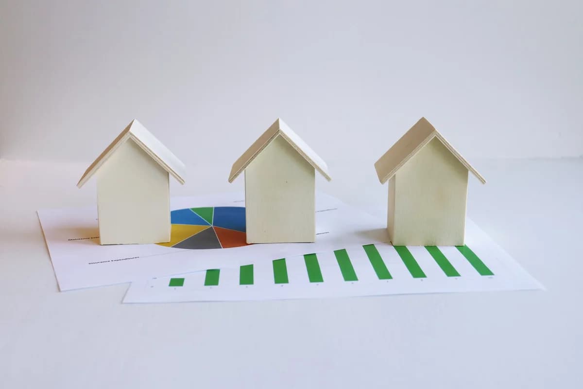 Wooden house models on housing market charts