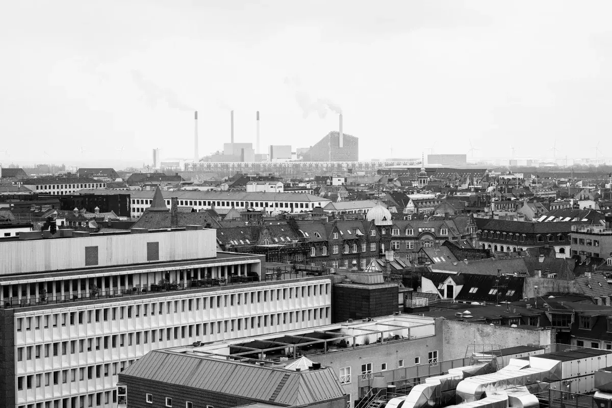 Black-and-white aerial view of Copenhagen rooftops and city buildings.