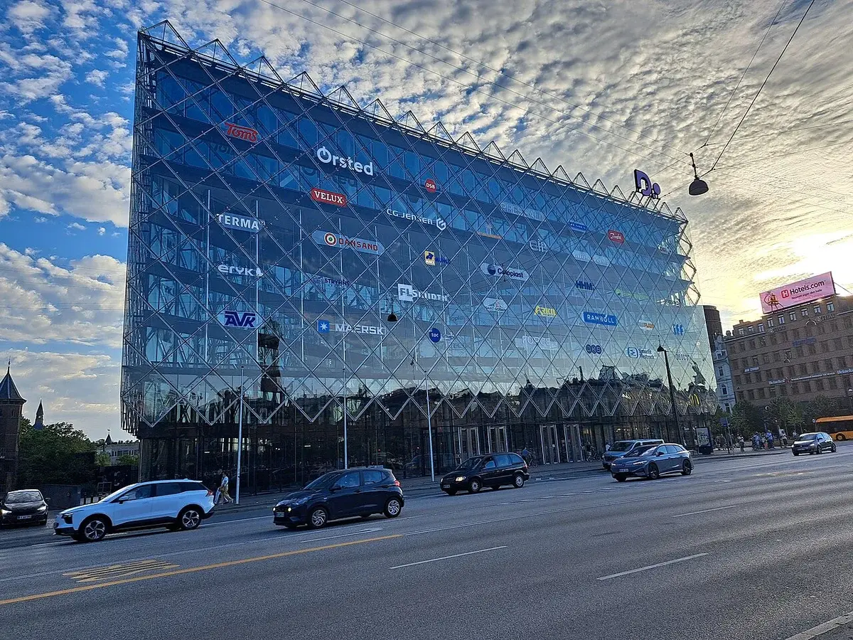 Modern glass building in Copenhagen with logos on the facade