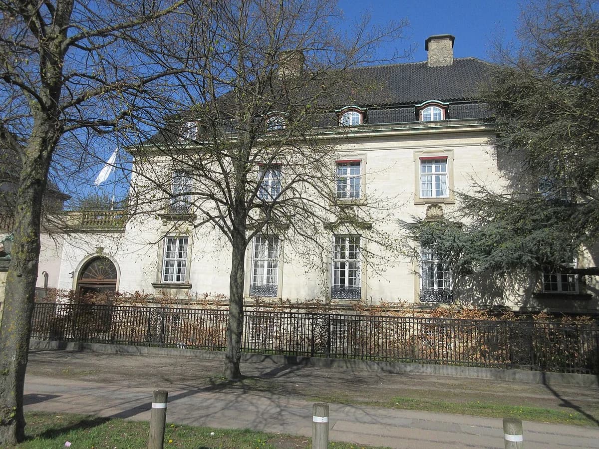 Historic building behind trees on a Copenhagen street.