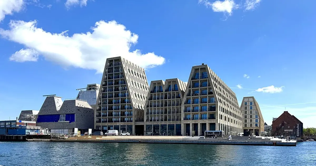 Modern waterfront buildings at Papirøen in Copenhagen under a blue sky.