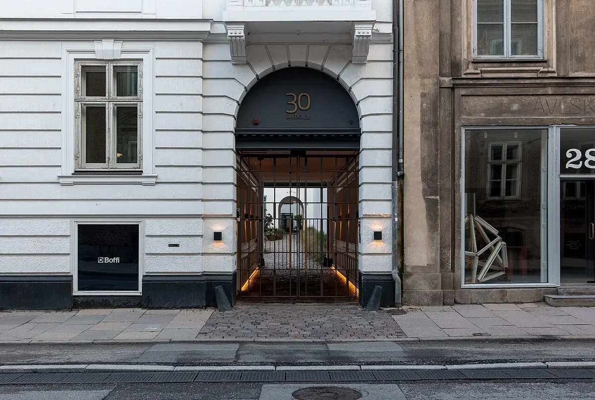 Historic buildings on Bredgade in Copenhagen with an arched entrance at number 30.