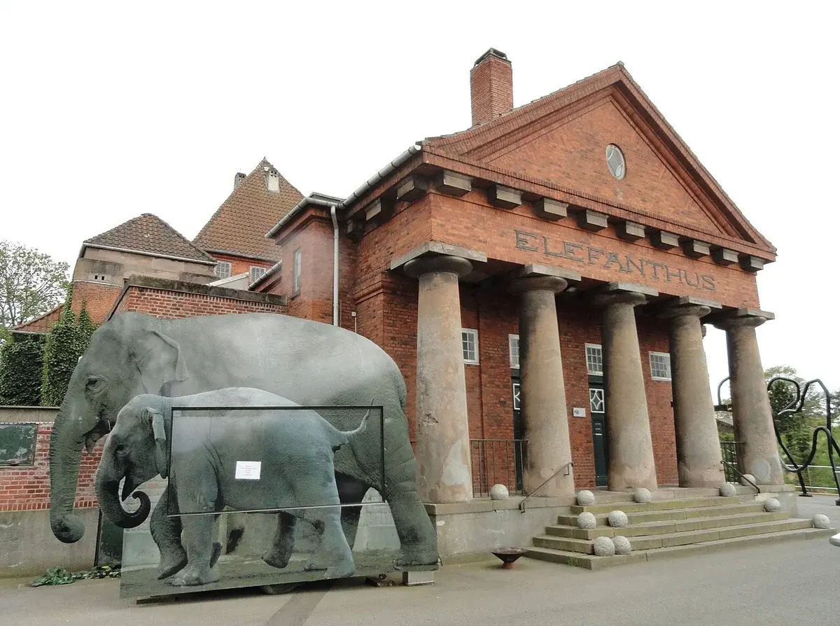 Brick elephant house building at Copenhagen Zoo with elephant sculptures in front.